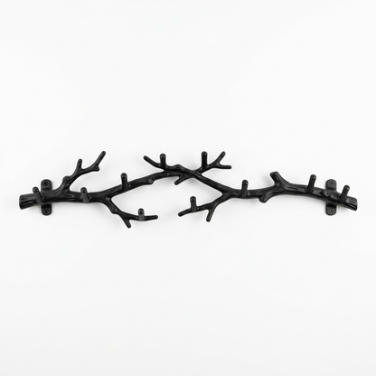 Black tree-branch wall-mounted coat rack on a white background