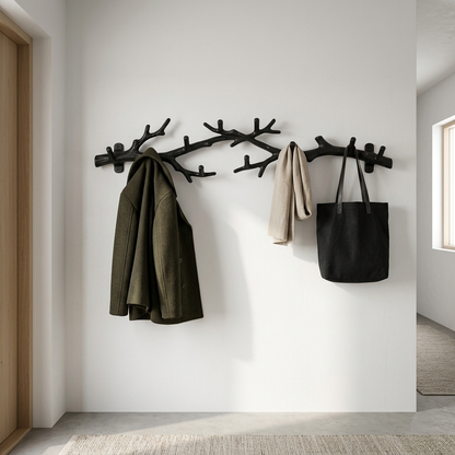 Black tree-branch wall-mounted coat rack styled in a room setting